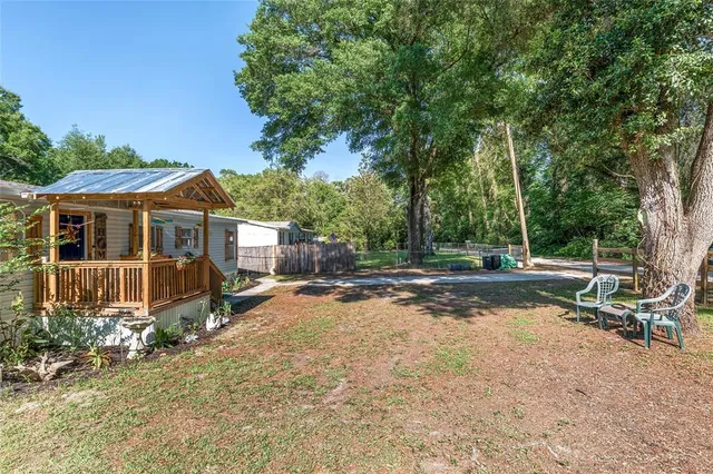 a view of a house with a yard and sitting area