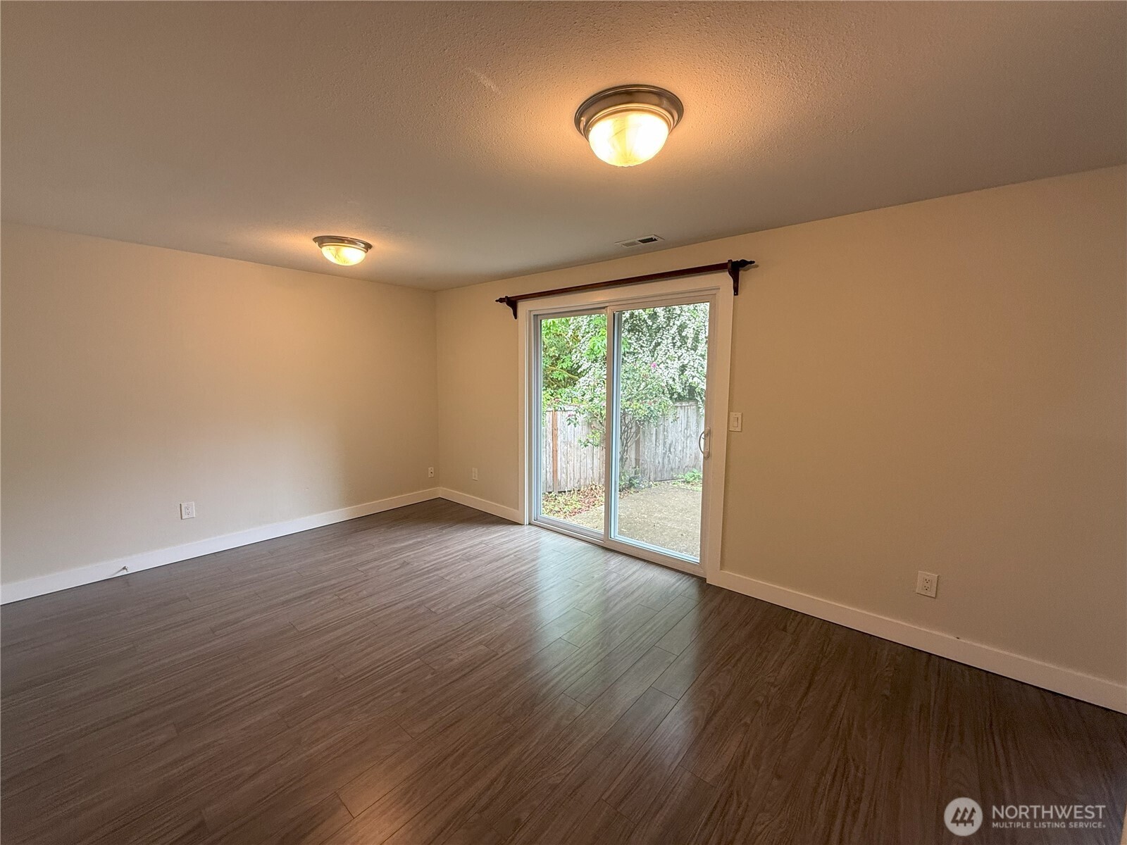 8820 Prentice Avenue Gig Harbor, WA 98332 - Photo 9 of 13 a view of an empty room with wooden floor and a window