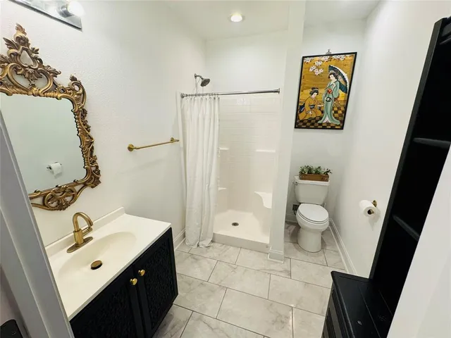 a bathroom with a sink mirror vanity and toilet