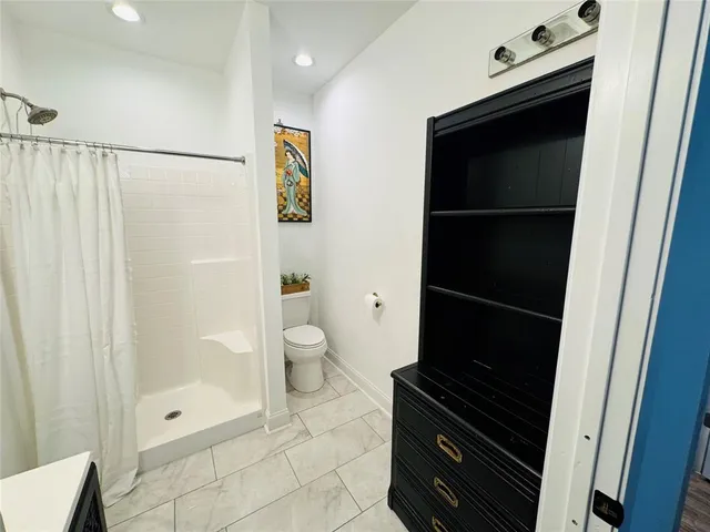 a bathroom with a toilet a sink and shower