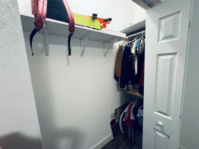 a view of walk in closet with clothes and shoes