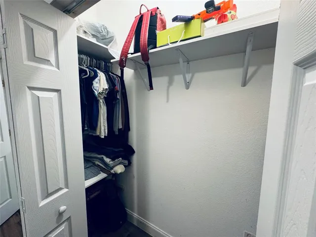 a view of walk in closet with clothes and shoes