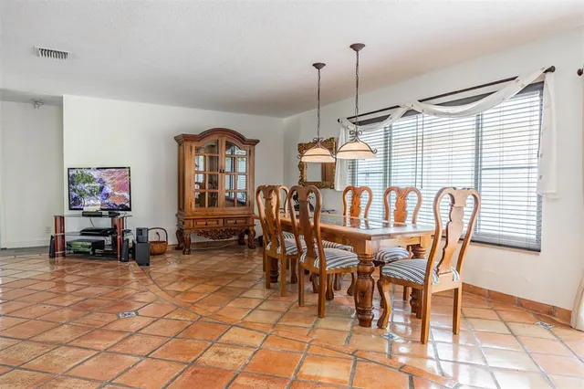 a living room with furniture a flat screen tv and floor to ceiling window