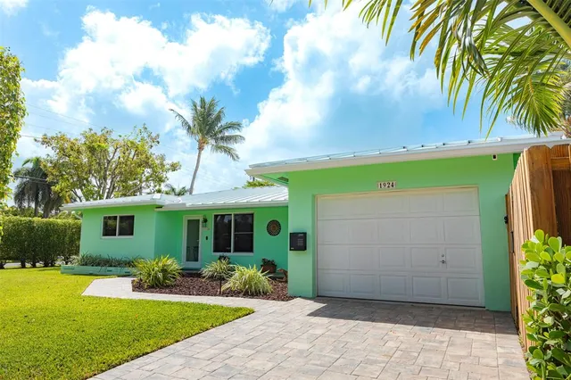 a view of a house with a yard and potted plants