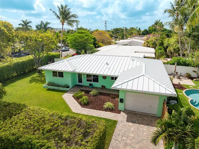 a view of a house with a yard and potted plants