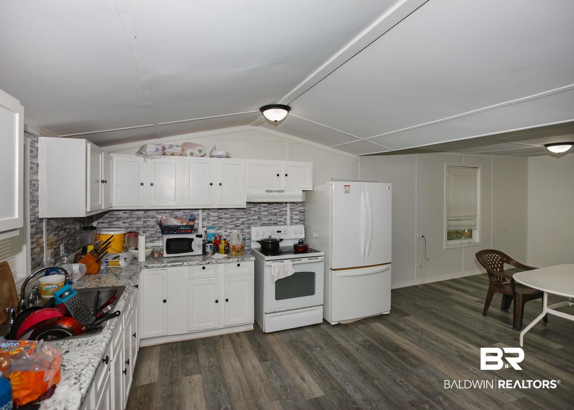 11998 Workman Avenue Foley, AL 36535 - Photo 8 of 59 Kitchen featuring white appliances, dark wood-style floors, white cabinetry, and lofted ceiling