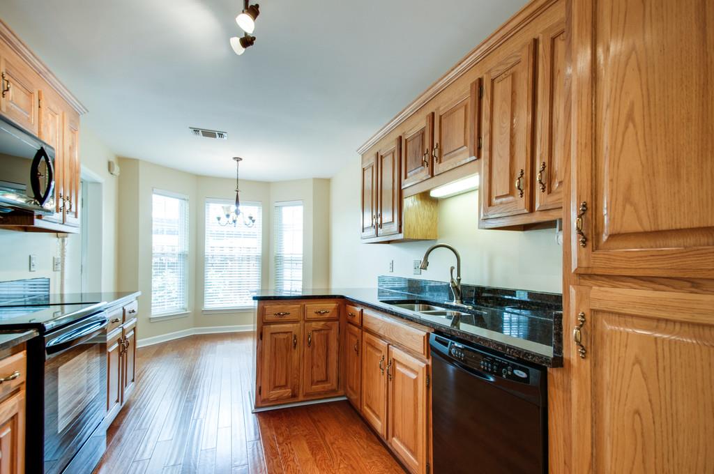 520 General George Patton Road Nashville, TN 37221 - Photo 11 of 30 a kitchen with stainless steel appliances granite countertop a sink dishwasher stove and wooden cabinets with wooden floor