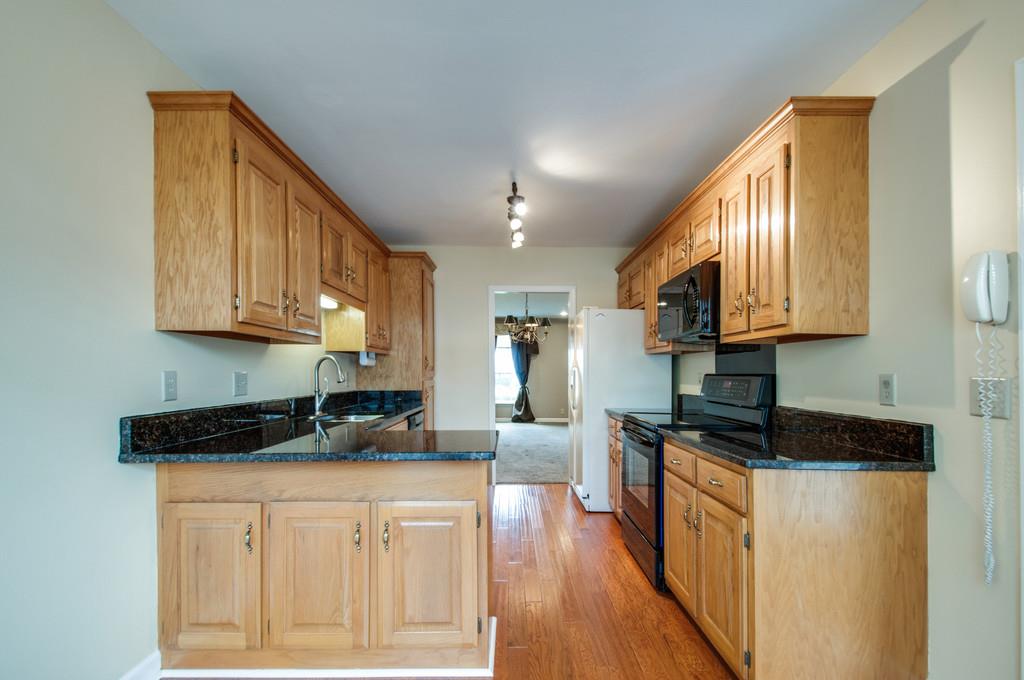 520 General George Patton Road Nashville, TN 37221 - Photo 12 of 30 a kitchen with stainless steel appliances granite countertop a sink a stove a refrigerator cabinets and wooden floor