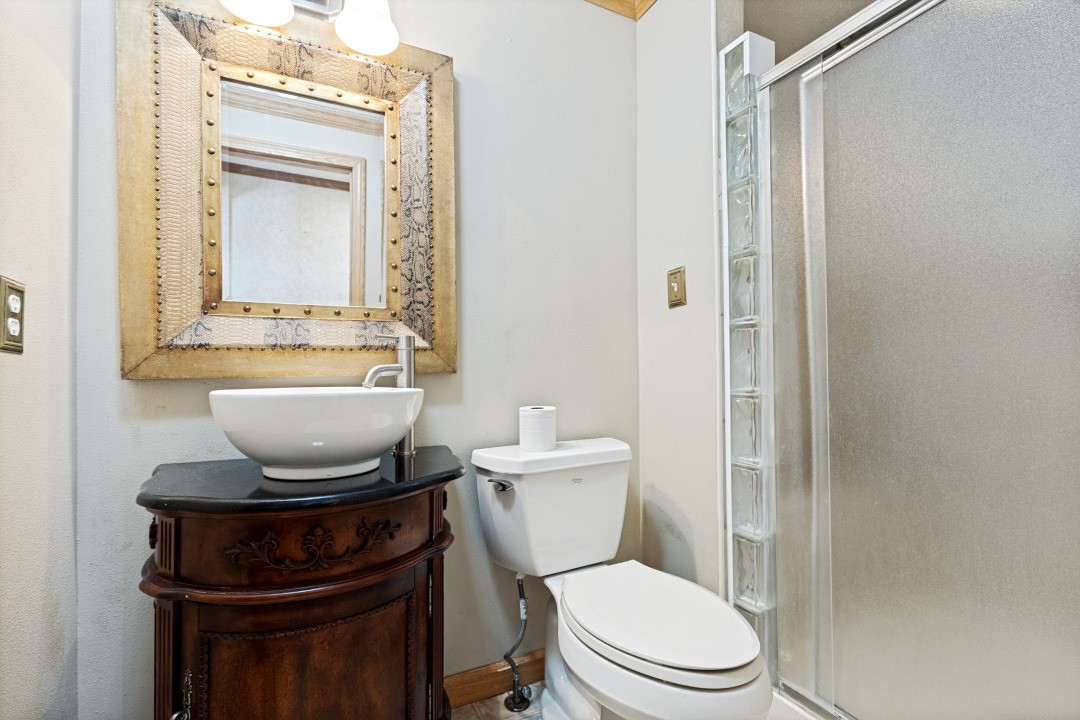 207 Vivian Road Onalaska, TX 77360 - Photo 26 of 34 a bathroom with a toilet a sink and a mirror