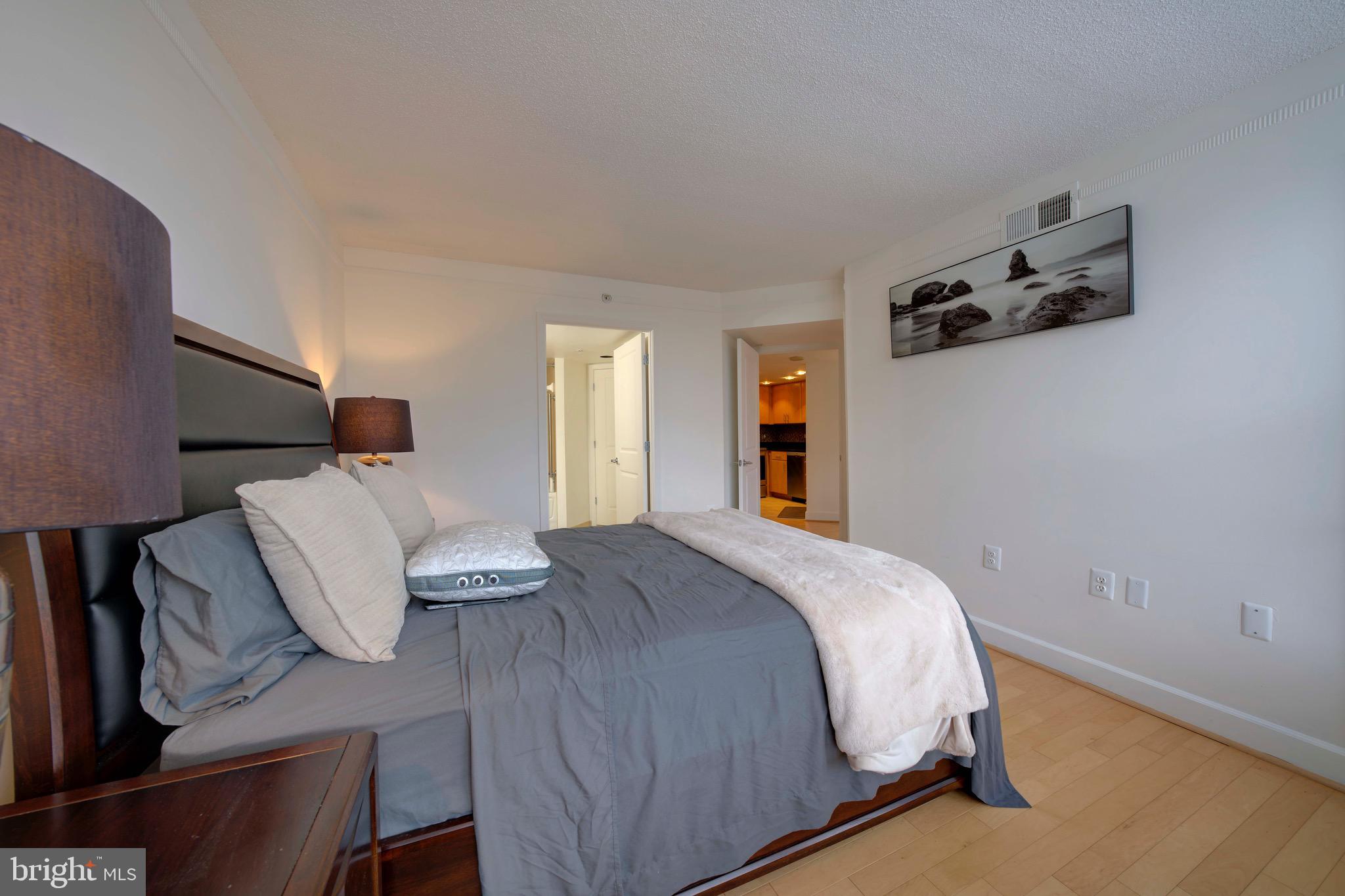 11800 Sunset Hills Road, Unit 222 Reston, VA 20190 - Photo 25 of 70 a bedroom with a bed and wooden floor