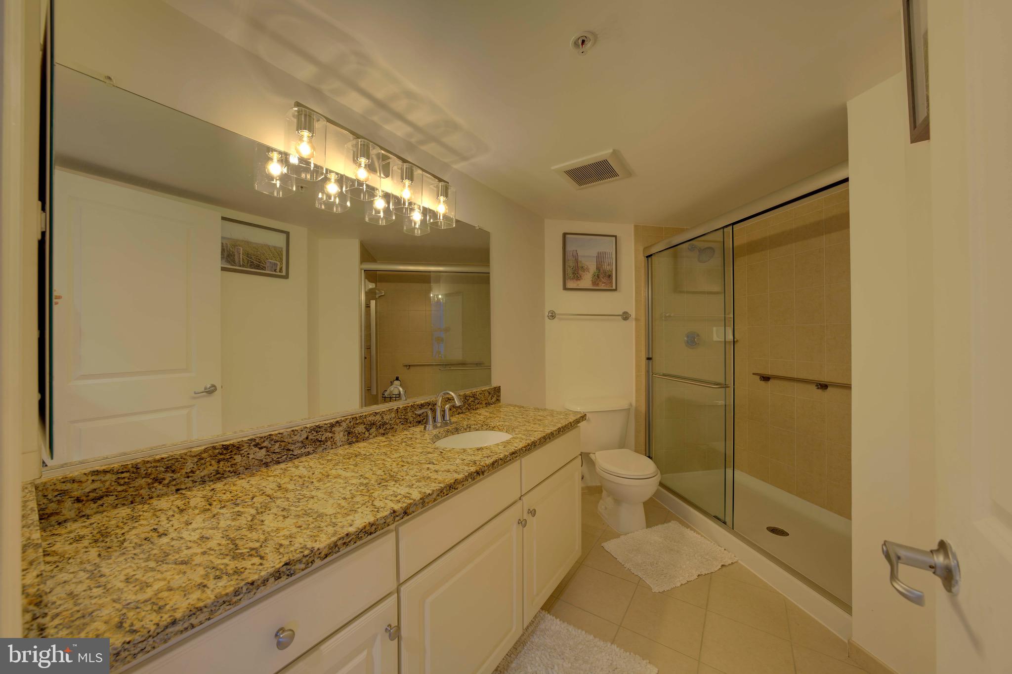 11800 Sunset Hills Road, Unit 222 Reston, VA 20190 - Photo 32 of 70 a bathroom with a granite countertop sink a toilet and shower