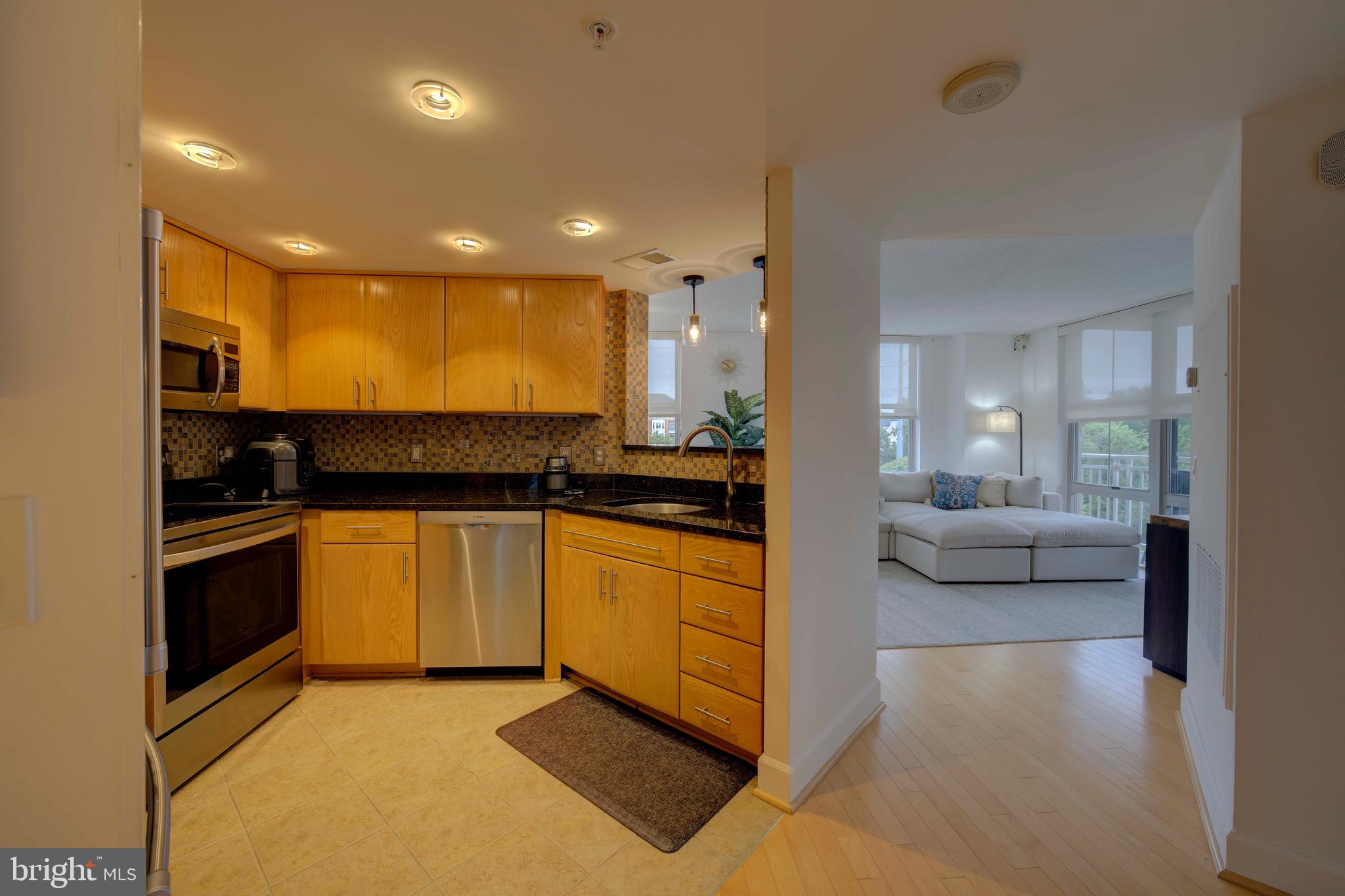 11800 Sunset Hills Road, Unit 222 Reston, VA 20190 - Photo 7 of 70 a large white kitchen with stainless steel appliances granite countertop a stove and a sink