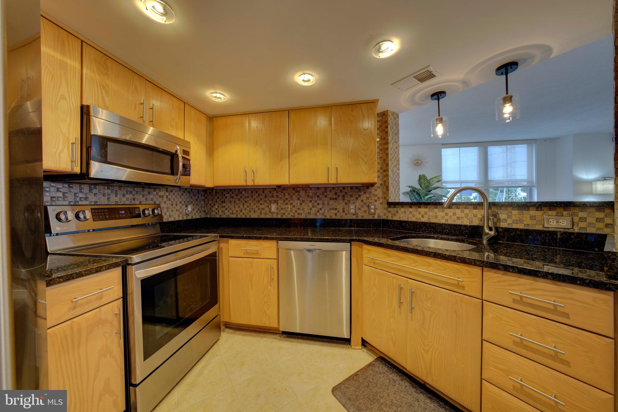 11800 Sunset Hills Road, Unit 222 Reston, VA 20190 - Photo 9 of 70 a kitchen with stainless steel appliances granite countertop a stove a sink and a microwave