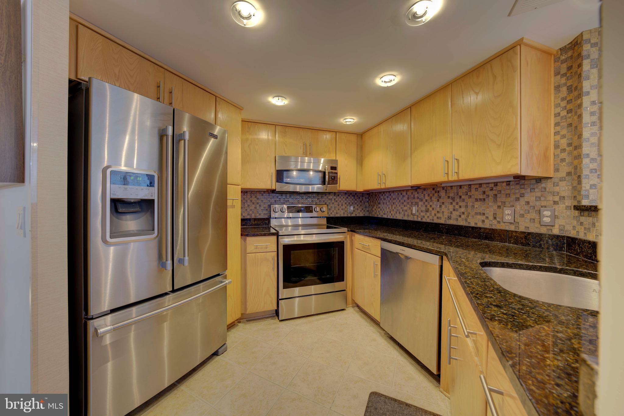 11800 Sunset Hills Road, Unit 222 Reston, VA 20190 - Photo 10 of 70 a kitchen with stainless steel appliances granite countertop a refrigerator a stove and a sink