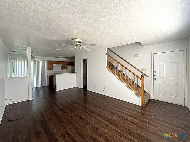 a view of a kitchen with wooden floor and electronic appliances