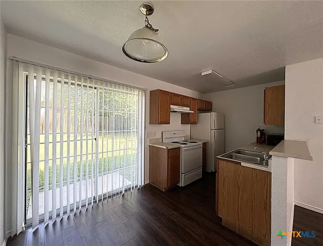 a kitchen with a stove a sink and a refrigerator