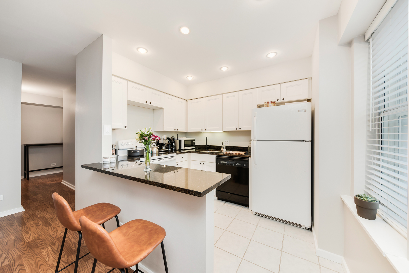 40 East 9th Street, Unit 715 Chicago, IL 60605 - Photo 8 of 19 a kitchen with refrigerator and chairs