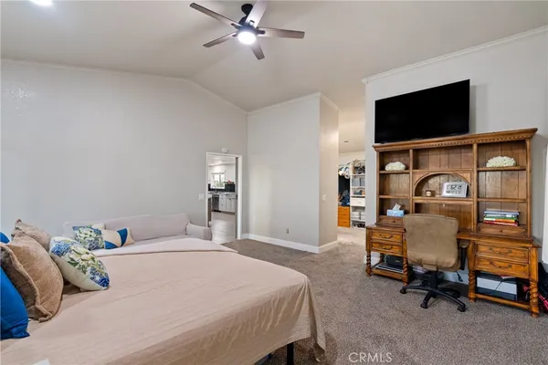 a bedroom with a bed and a flat tv screen on the dresser