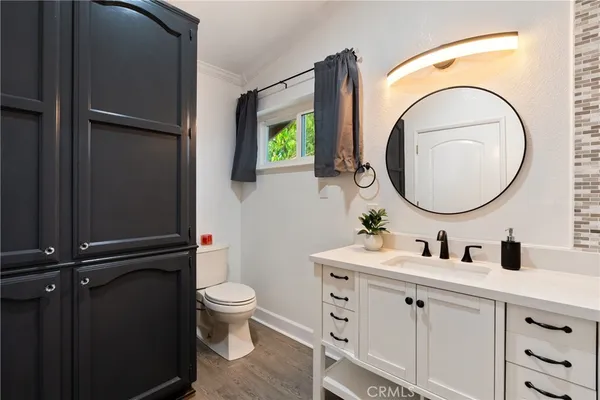 a bathroom with a granite countertop toilet sink and mirror