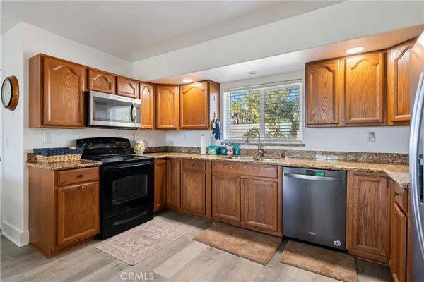 a kitchen with granite countertop a stove top oven sink cabinetry and granite countertops