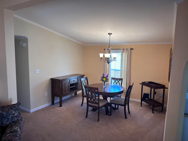 a view of a dining room with furniture and chandelier