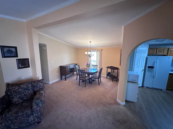 a living room with furniture and a dining table with kitchen view