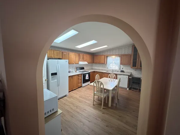 a kitchen with a dining table chairs and refrigerator