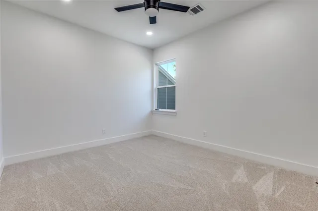 en empty room with windows and ceiling fan