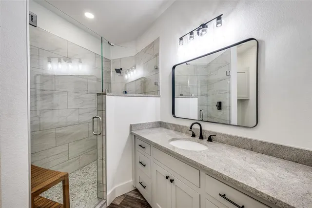 a bathroom with a shower sink and mirror