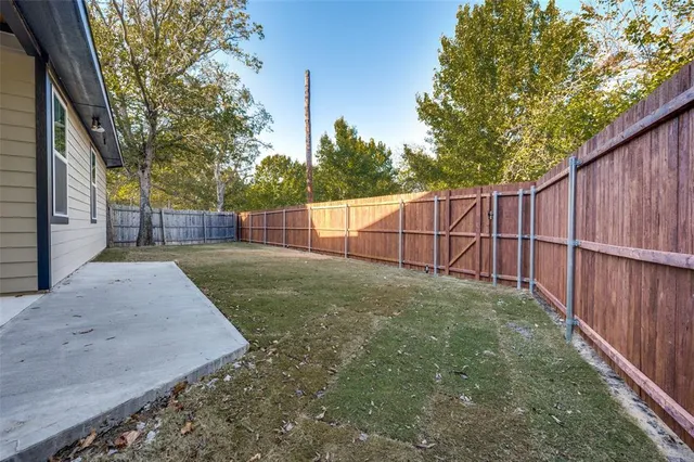 a view of a backyard with wooden fence