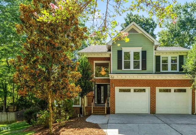 a front view of a house with a tree