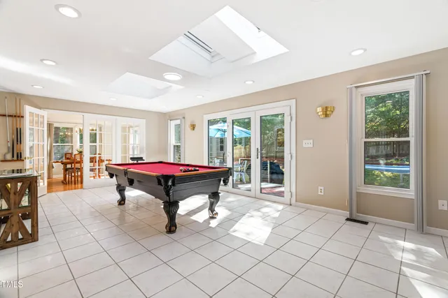 a room with pool table and windows