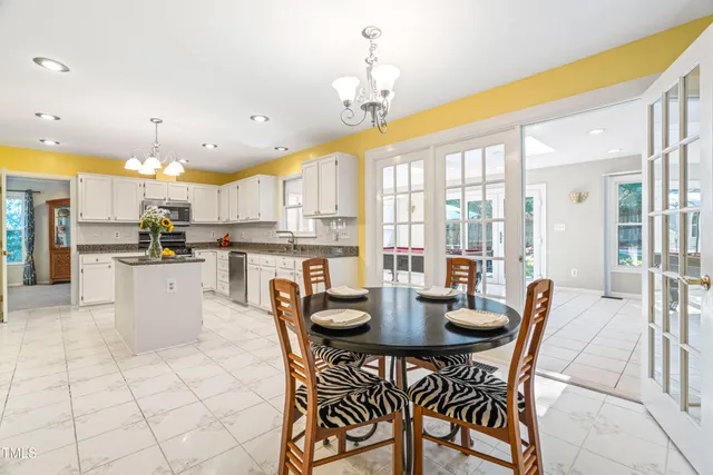 a kitchen with stainless steel appliances granite countertop a sink dishwasher and white cabinets with a granite countertops