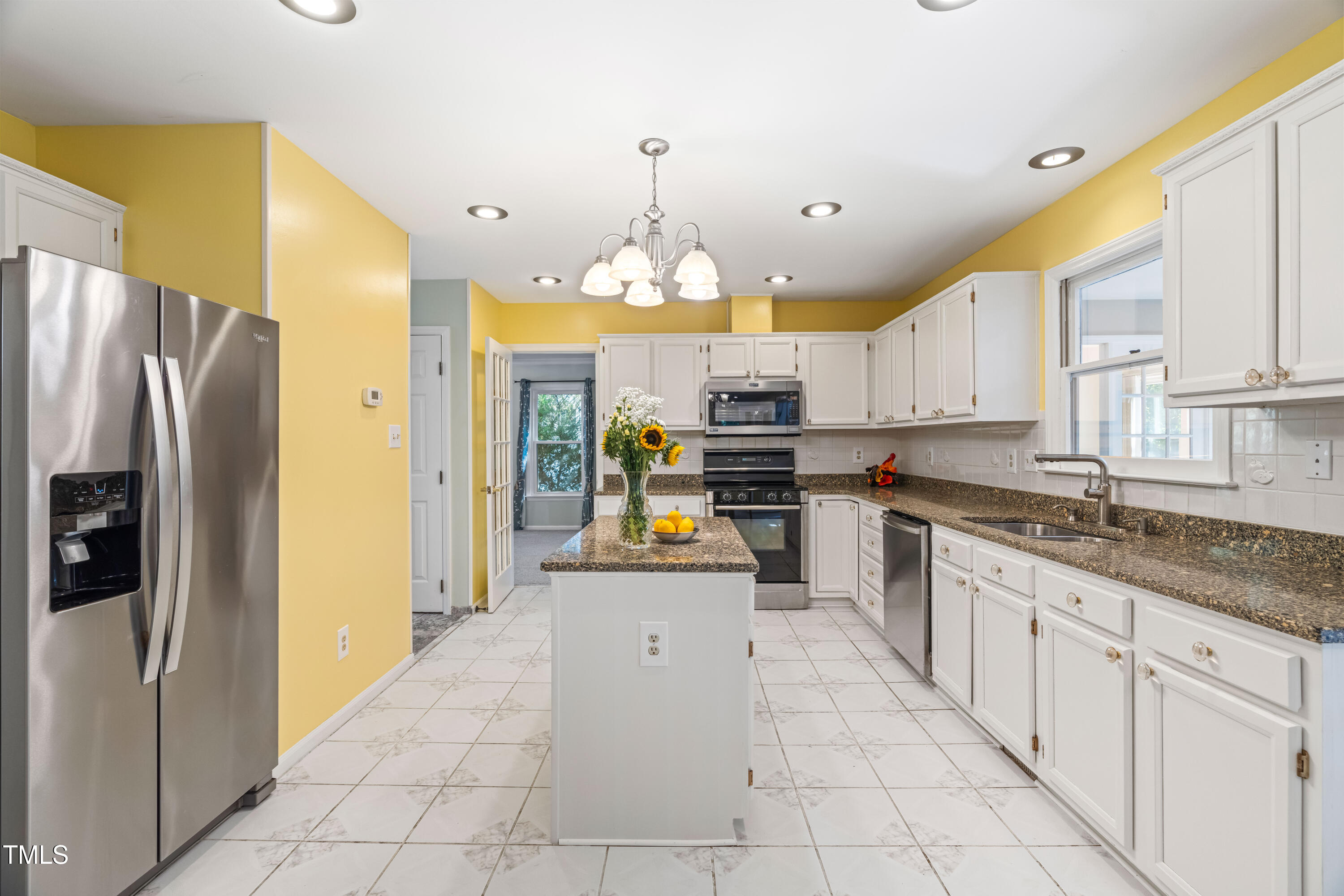 1106 Wellstone Circle Apex, NC 27502 - Photo 28 of 67 a kitchen with granite countertop a center island stainless steel appliances cabinets and a counter top space