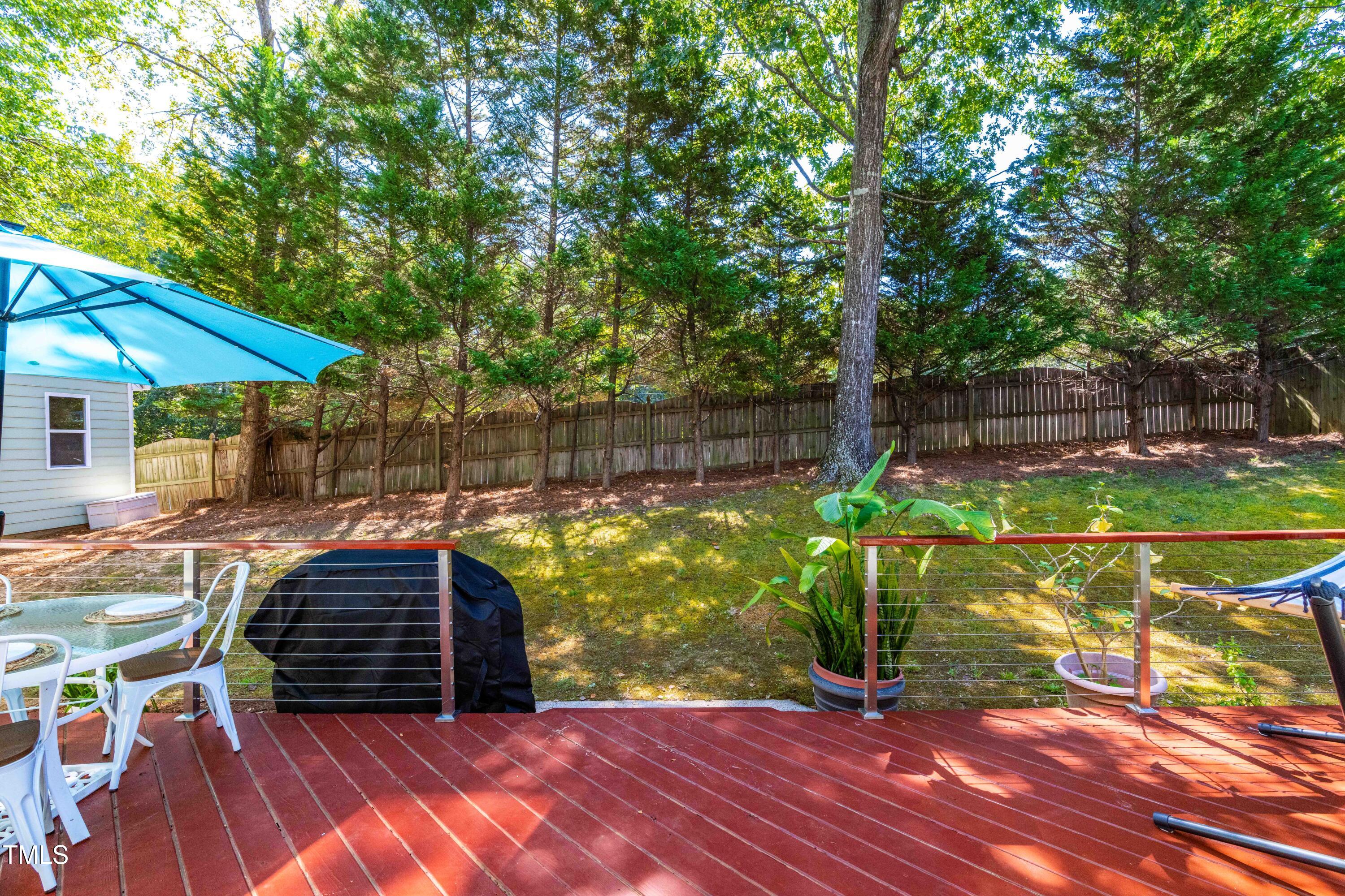 1106 Wellstone Circle Apex, NC 27502 - Photo 51 of 67 a view of a patio with table and chairs potted plants and large tree
