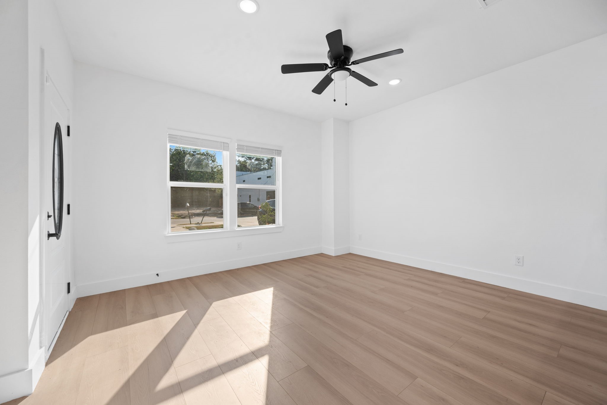 8410 Sunnyhill Street Houston, TX 77088 - Photo 19 of 20 a view of empty room with wooden floor and fan