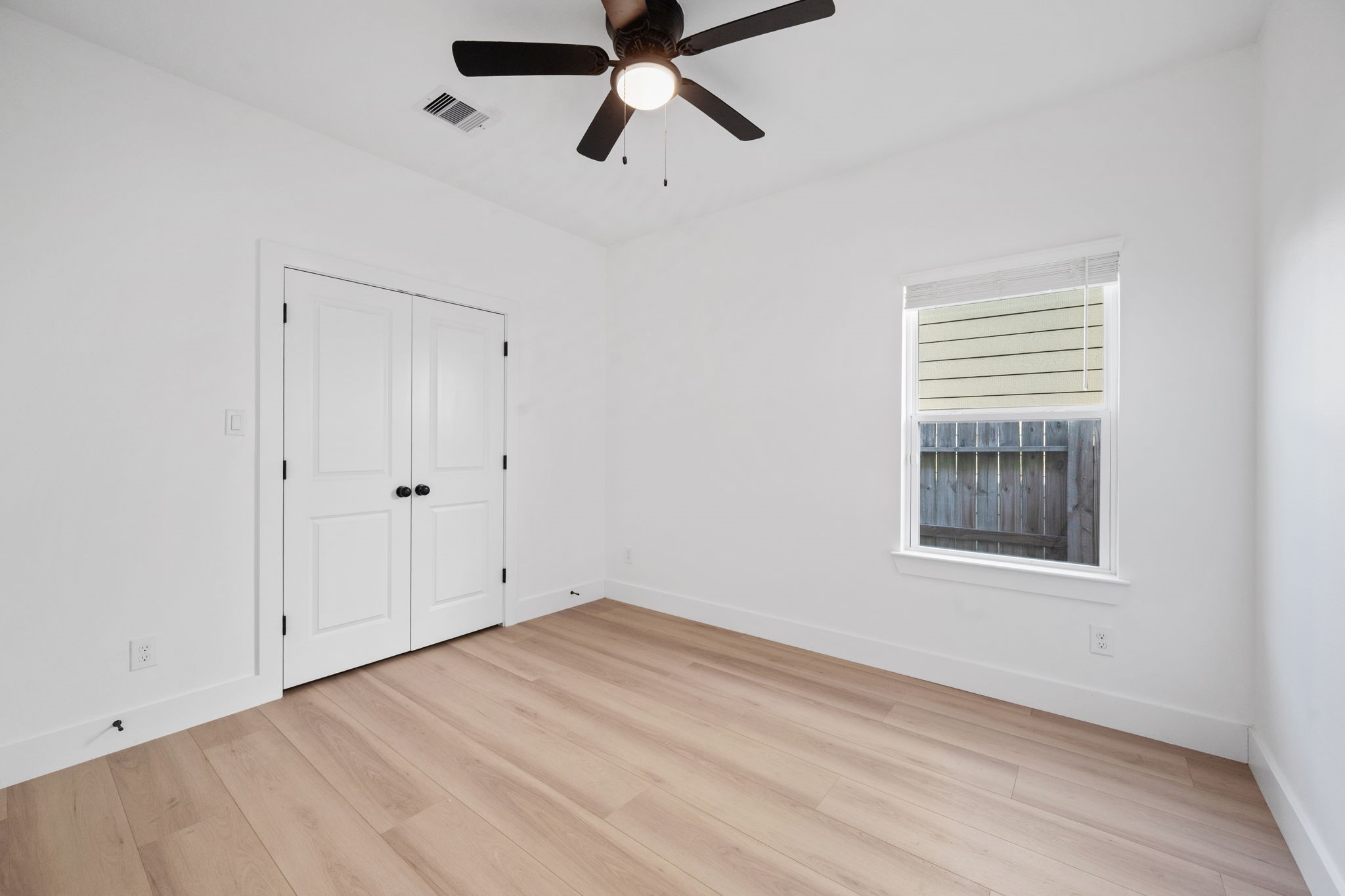 8410 Sunnyhill Street Houston, TX 77088 - Photo 5 of 20 a view of an empty room with a window and a ceiling fan