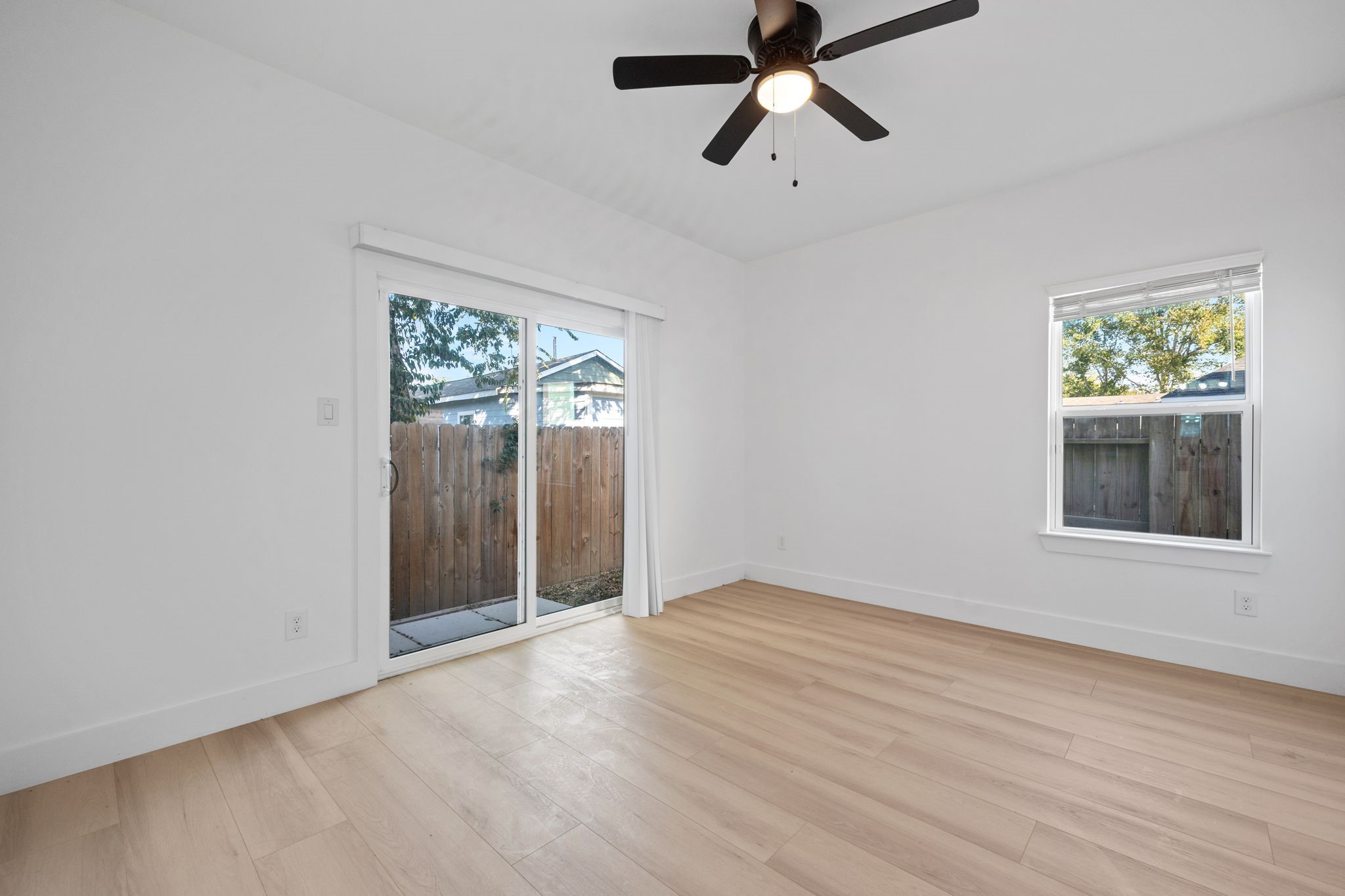 8410 Sunnyhill Street Houston, TX 77088 - Photo 7 of 20 wooden floor in an empty room with a window