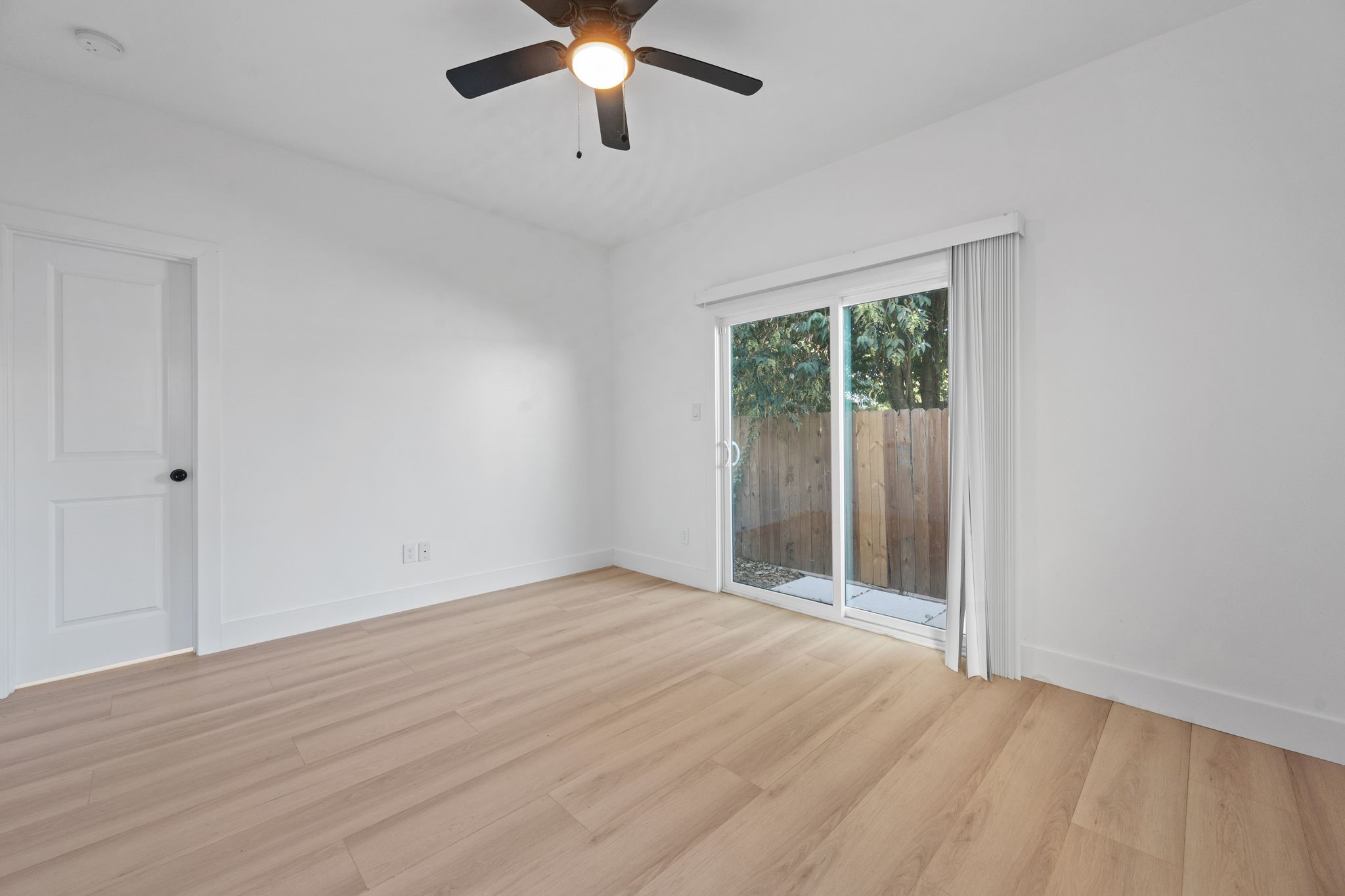 8410 Sunnyhill Street Houston, TX 77088 - Photo 8 of 20 wooden floor in an empty room with a window
