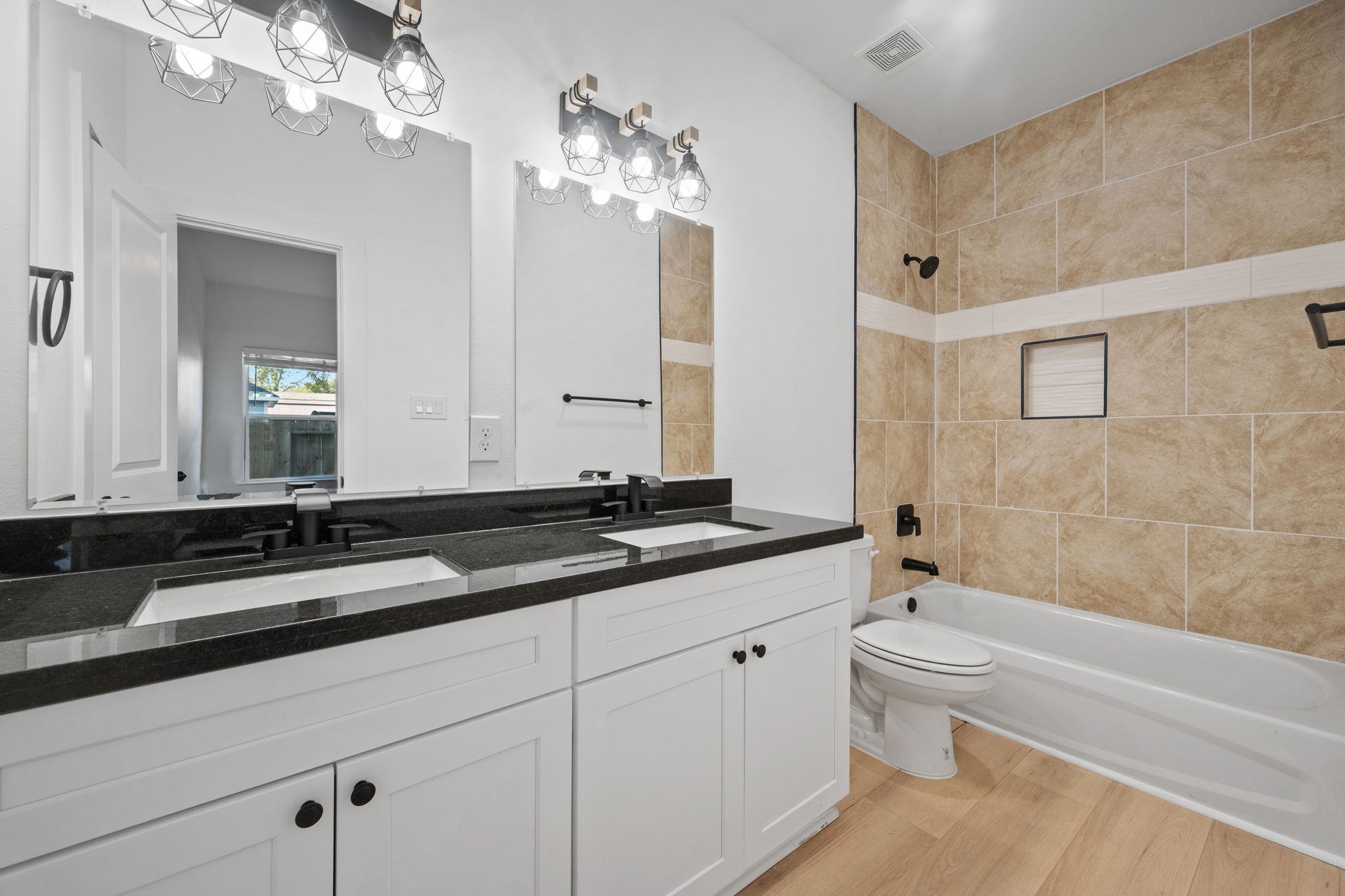 8410 Sunnyhill Street Houston, TX 77088 - Photo 10 of 20 a spacious bathroom with a granite countertop sink a toilet a mirror a bathtub and shower