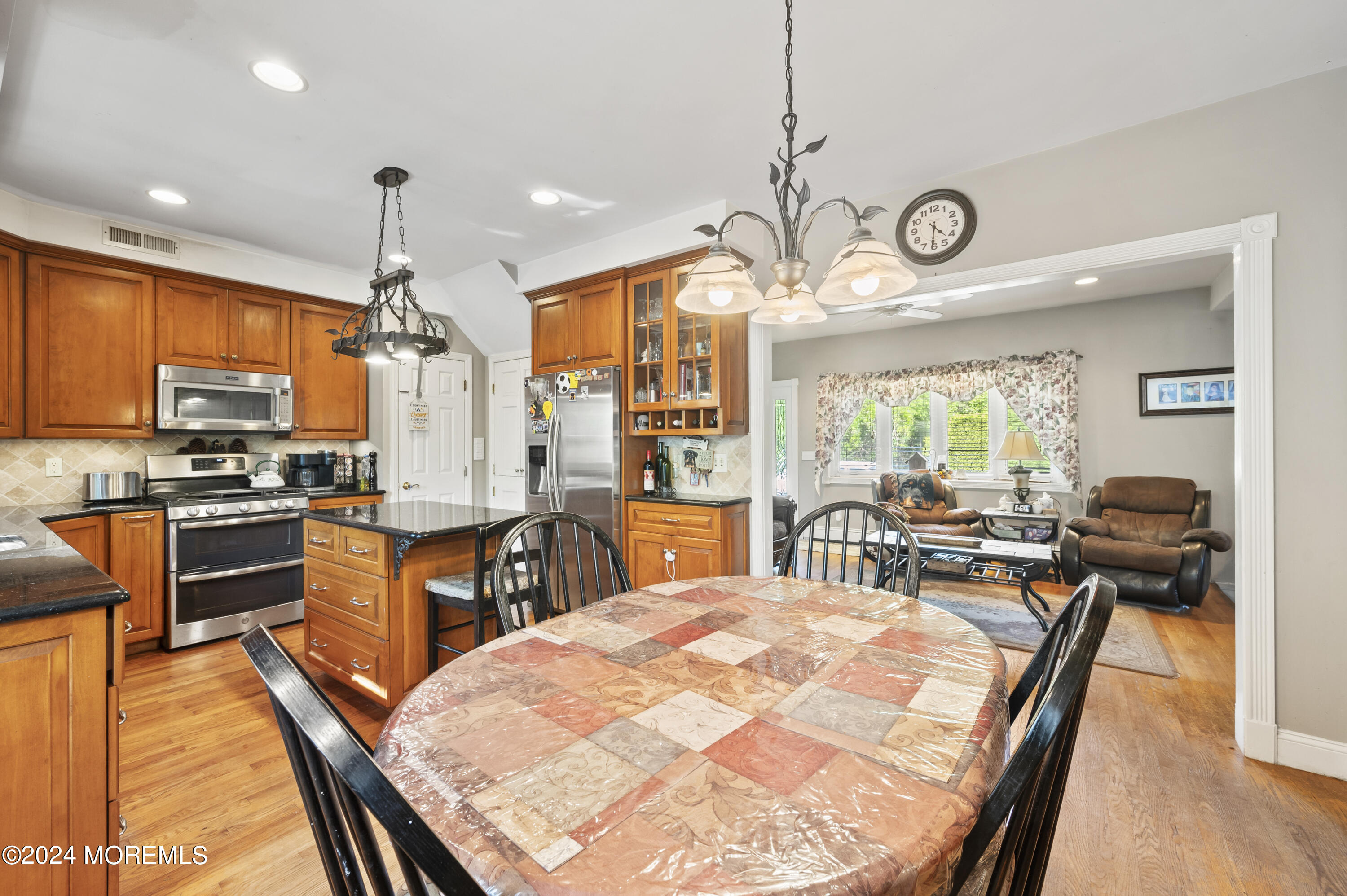 114 Andrew Lane Brick, NJ 08724 - Photo 13 of 54 a kitchen with stainless steel appliances kitchen island granite countertop a stove top oven a sink a dining table and chairs with wooden floor