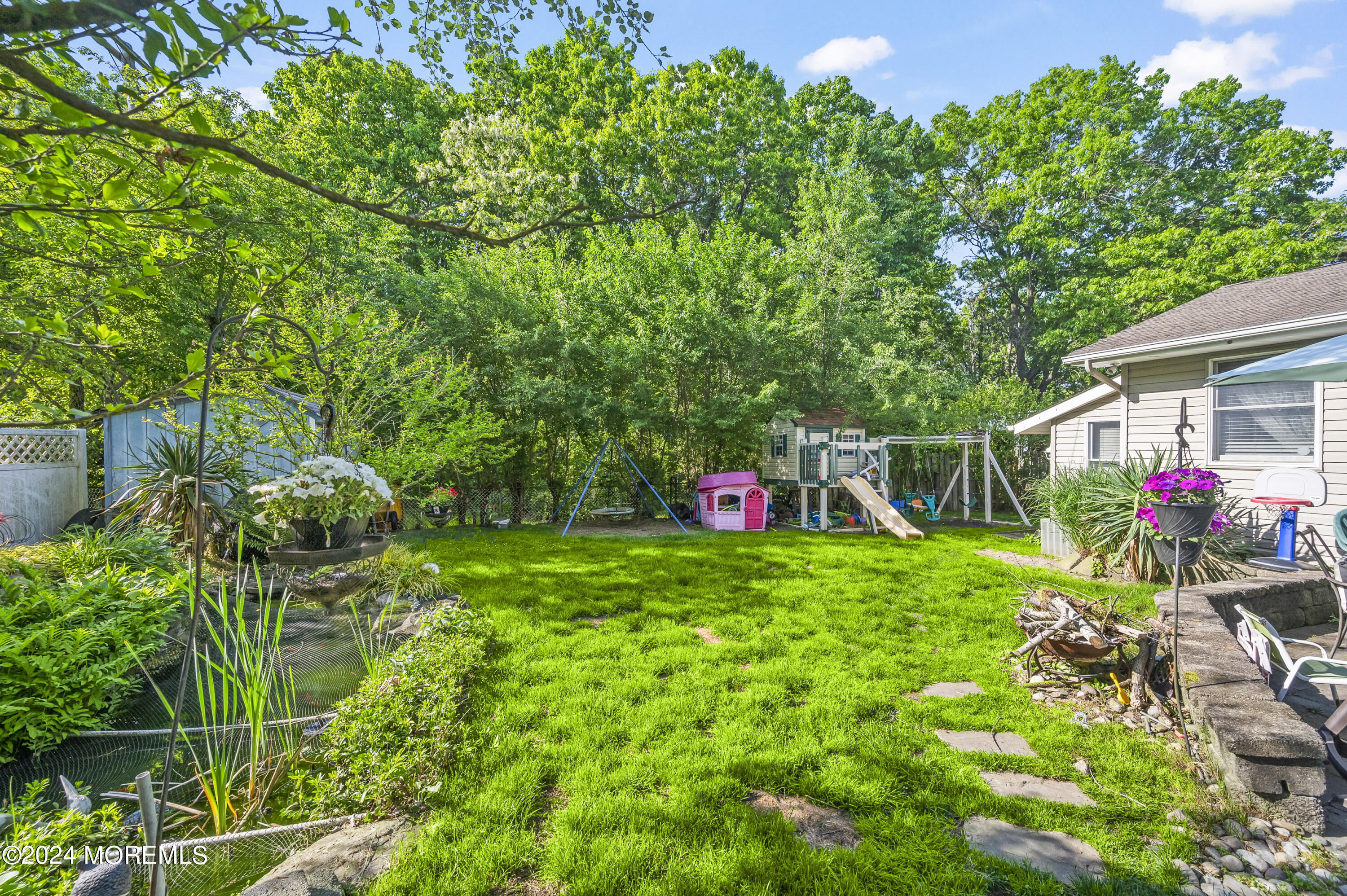 114 Andrew Lane Brick, NJ 08724 - Photo 24 of 54 a backyard of a house with lots of green space and a fountain