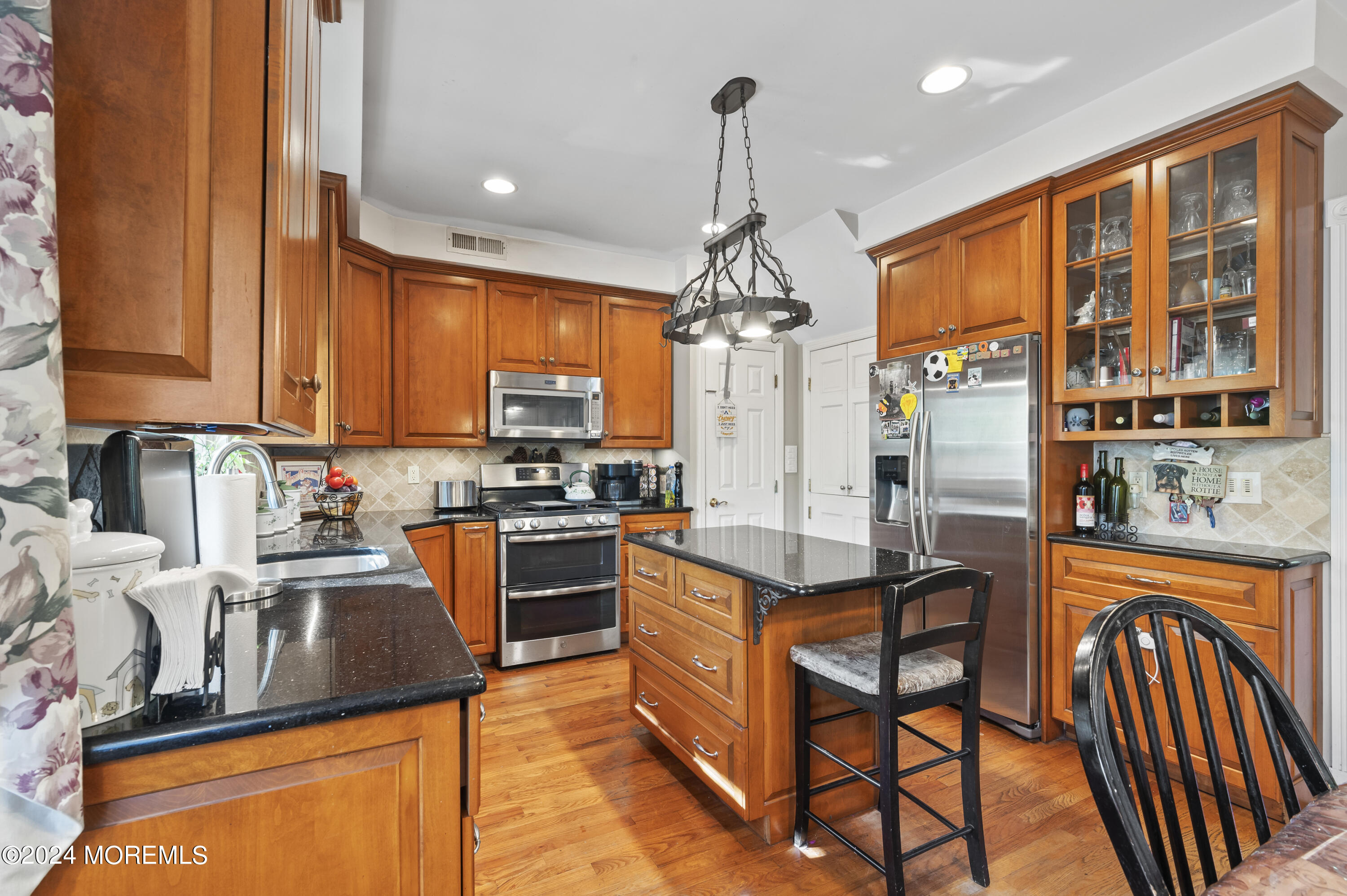 114 Andrew Lane Brick, NJ 08724 - Photo 6 of 54 a kitchen with stainless steel appliances granite countertop a stove top oven a sink dishwasher a dining table and chairs with wooden floor