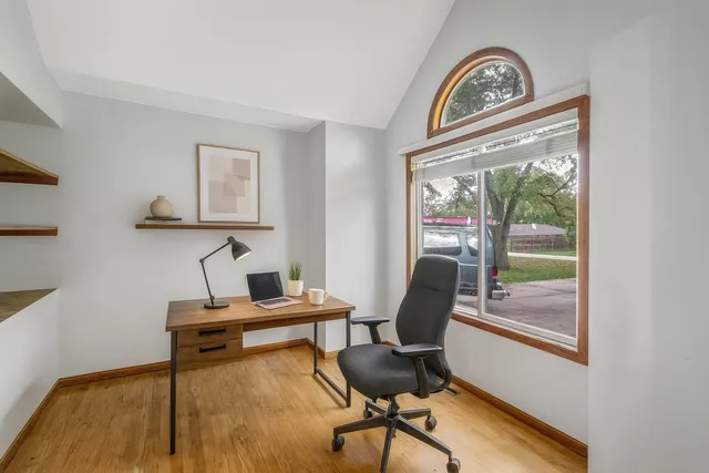 a view of a workspace with furniture and a window