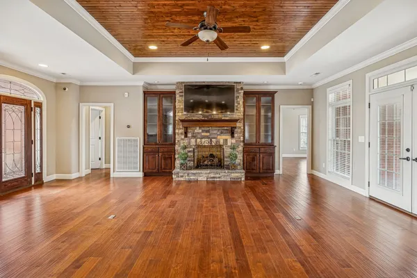 a view of a livingroom with wooden floor and a ceiling fan