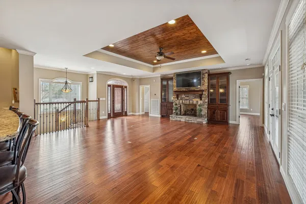 a view of a room with wooden floors and ceiling fan