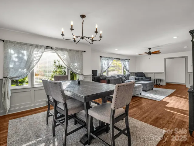 a view of a dining room with furniture a chandelier and wooden floor