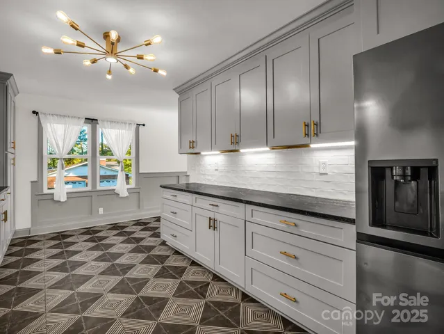 a kitchen with granite countertop a stove a sink and a refrigerator