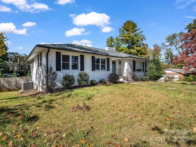 a front view of house with yard and trees around