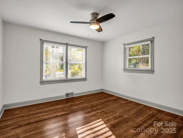 a view of empty room with wooden floor and window